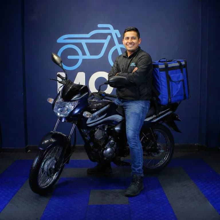 Repartidor posando con su motocicleta de trabajo Motai